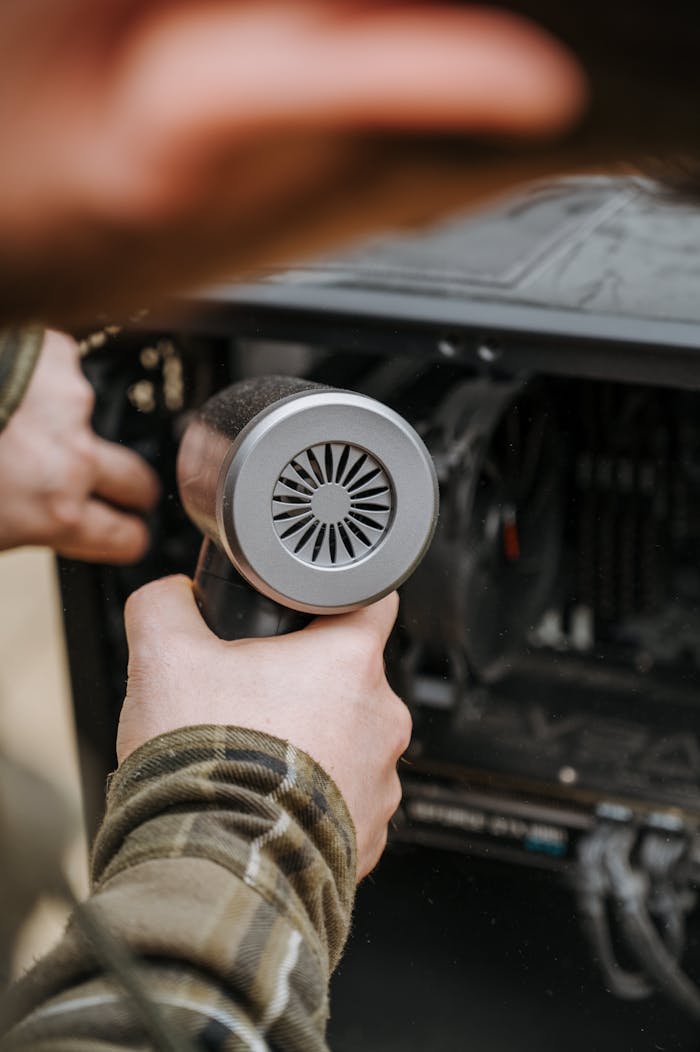 Mastering the First Impression: Your intriguing post title goes here Close-up of an adult cleaning a computer's interior with an air duster for maintenance.