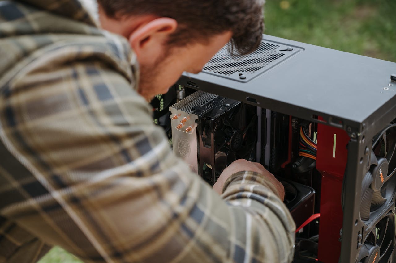 Home A man cleans and maintains a desktop PC outdoors with precision.