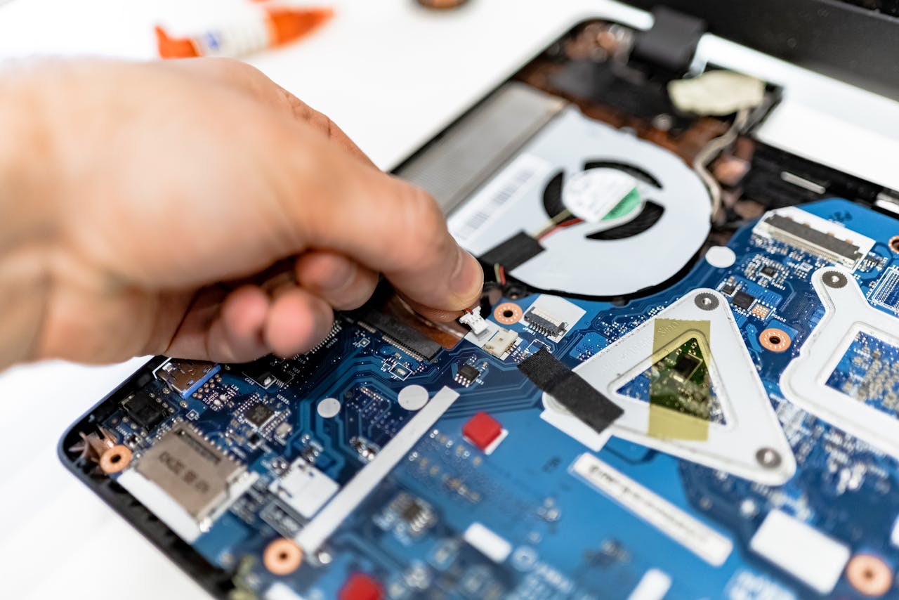 Offerings Close-up view of a hand fixing a computer motherboard showcasing technology and electronics repair.